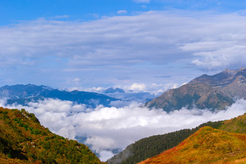 landscape - view from the mountain top on a sunny day to the valley hidden by low clouds