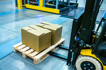 Forklift yellow. Warehouse automation. The boxes are on the forklift forks. Warehousing. Logistics...