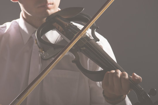 The musician plays the electronic violin. Violin close up.