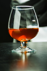 A glass with a red drink and glare on the glass.