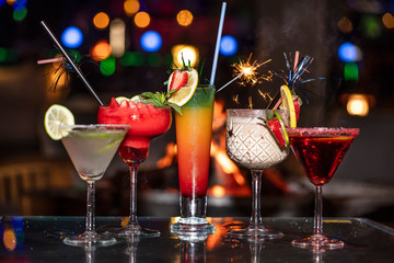Alcoholic cocktail row on bar table, colorful party drinks