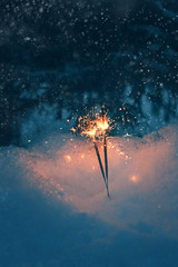 Sparkler in the snow.  Christmas and new year holiday. soft focus