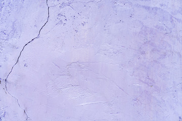 Natural background. Wall with a shabby and peeling paint, crack and plaster.  purple, violet