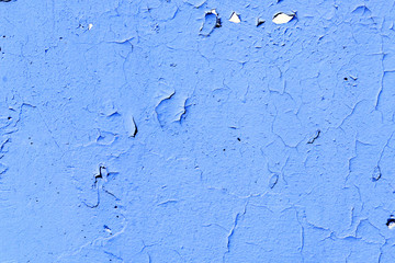 Natural background. Wall with a shabby and peeling paint, crack and plaster. blue and indigo
