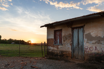 Fototapeta na wymiar casa na fazenda com pôr-do-sol