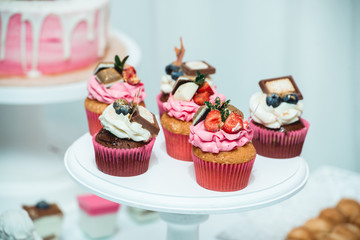 white stand with cupcakes on a candy bar table