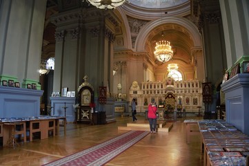 Inside of a large, modern church with pews and cross visible