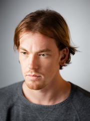 Obraz premium Male portrait of a fair-haired man of European appearance, on a white background. Emotions. Serious face