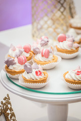 Obraz na płótnie Canvas white stand with cupcakes on a candy bar table