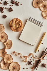 notebook with pen, muffin, dried apples on a white background. hygge style