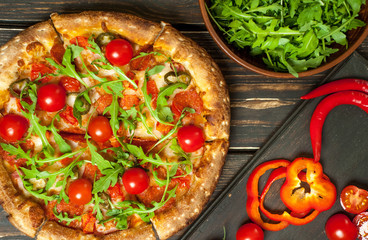 pizza on wood table with ingredients