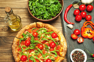 pizza on wood table with ingredients