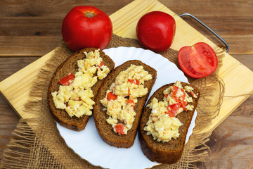 Fried eggs with tomatoes on bread. Light breakfast