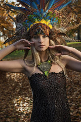 Pretty blonde wearing coronet made of peacock's feathers