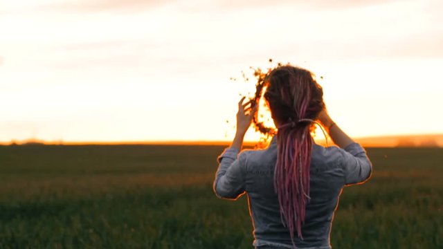 Flowers in the field. Girl in the field. Pagan Slavic rite. Pagan rite. Paganism. Sunset. Going into the sunset. Girl walks through the field. Girl during sunset