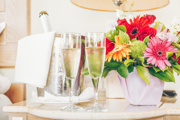 Two glasses of champagne in the upscale hotel room. Dating, romance, honeymoon, valentine, getaway concepts