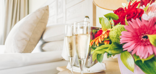 Two glasses of champagne in the upscale hotel room. Dating, romance, honeymoon, valentine, getaway...