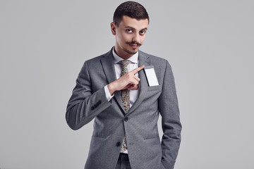 Handsome young arabic businessman with mustache in fashion gray suit