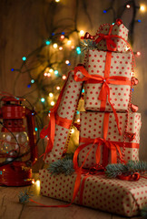 New Year's gifts with red ribbon. Packing Christmas gifts. Garland with lights. New Year.