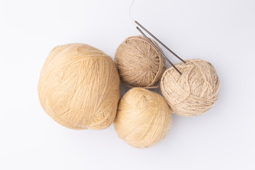 grey wool, skeins of yarn and knitting needles on white background, top view, flat lay