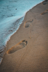 Footprints almost getting washed away by the ocean