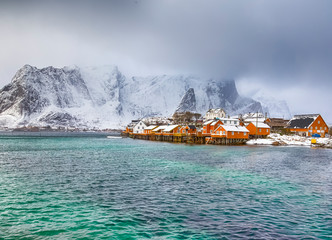 View of Scenic Lofoten Islands Archipelago Spring Scenery with Traditional Yellow Fisherman Cabins in the Village of Sakrisoy at Sunrise in Norway