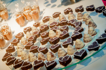 bonbons in rounded and heart-shaped shapes on glass tray