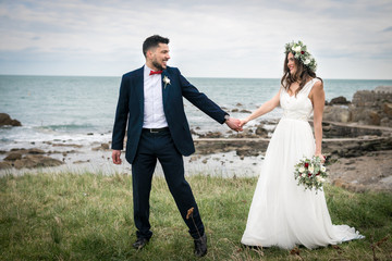 young couple bride groom getting married wedding posed photos at seaside sea beach hairpiece...