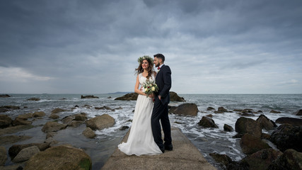 young couple bride groom getting married wedding posed photos at seaside sea beach hairpiece...