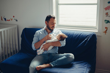 Portrait of middle age Caucasian father feeding newborn baby son daughter with milk. Male man...