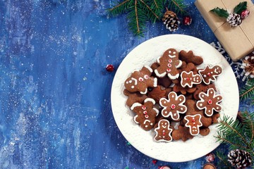Homemade Gingerbread cookies in a snowflate plate on festive X-mas background