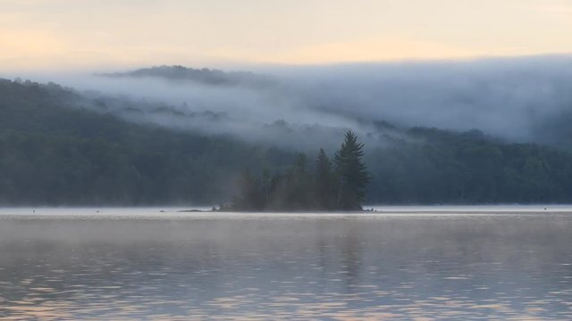 Misty morning with island. Eagle lake, Haliburton, Ontario, Canada.