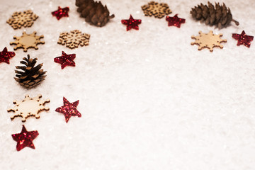 Christmas background, with red glitter stars, timber snowflakes, pines cones and snow - sophisticated, luxury - copyspace