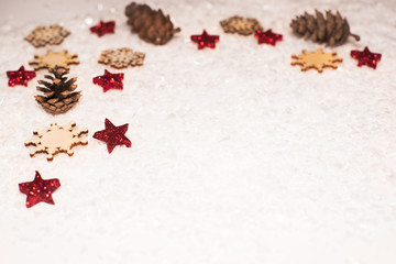 Christmas background, with red glitter stars, timber snowflakes, pines conesand snow - sophisticated, luxury - copyspace