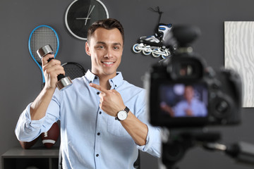 Sport blogger recording video on camera indoors