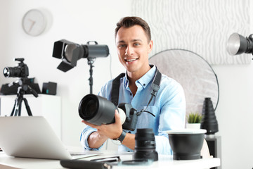 Portrait of photo blogger with camera and laptop at home
