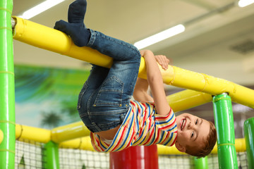 Cute little child playing at indoor amusement park