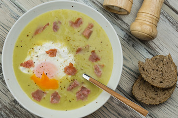 Asparagus cream soup. Delicious homemade green asparagus cream soup with poached egg and ham