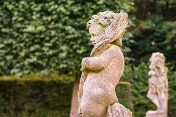 Stone angel statue in garden. Guardian angel statue in sunlight as a symbol of love in garden.