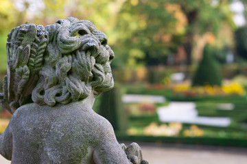 Fototapeta na wymiar Stone angel statue in garden. Guardian angel statue in sunlight as a symbol of love in garden.