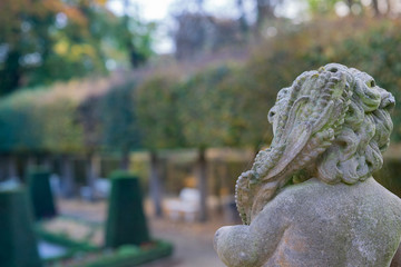 Stone angel statue in garden. Guardian angel statue in sunlight as a symbol of love in garden.