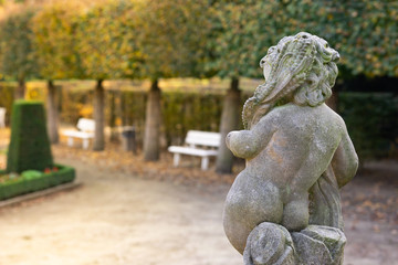 Stone angel statue in garden. Guardian angel statue in sunlight as a symbol of love in garden.