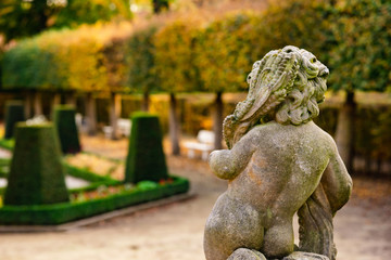 Stone angel statue in garden. Guardian angel statue in sunlight as a symbol of love in garden.