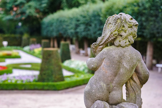 Stone angel statue in garden. Guardian angel statue in sunlight as a symbol of love in garden.