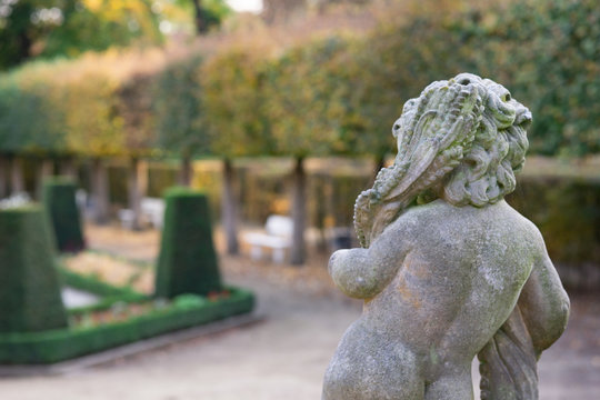 Stone angel statue in garden. Guardian angel statue in sunlight as a symbol of love in garden.