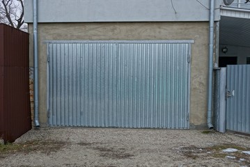facade of a private garage with gray metal gates in the street