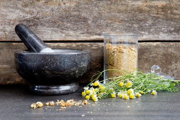 Dried chamomile flowers in gray / grey marble mortar and pestle (and apothecary jar)  together with...