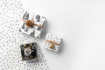 Christmas gift boxes on wrap background with gold decoration and pine cones. Xmas and Happy New Year theme. Flat lay, top view, wide composition