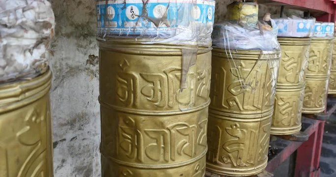 4k tibetan person turn spinning buddhist prayer wheels,lhasa.lhasa Tibetans wearing traditional clothing.