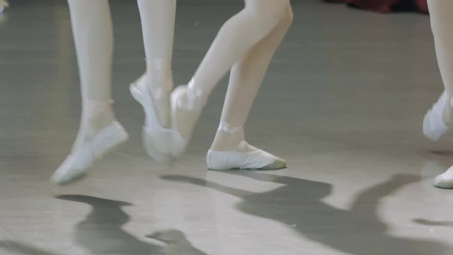 Ballet. Close-up of a girl's legs in white ballet shoes during ballet training. Element of classical dance. 4K.